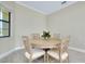 A sunlit dining area features a round table with four chairs and a large window at 20794 Valprato Ct, Venice, FL 34293