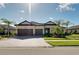 Charming single-story home showcasing a three-car garage, well-manicured lawn, and inviting curb appeal on a sunny day at 20794 Valprato Ct, Venice, FL 34293