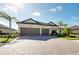 Beautiful home with a tile roof, two-car garage, mature landscaping and a brick driveway at 20794 Valprato Ct, Venice, FL 34293