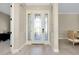 Inviting foyer featuring a decorative glass front door, tile flooring, and views into the dining area at 20794 Valprato Ct, Venice, FL 34293