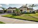 Beautiful property showcasing a tile roof, two-car garage, well-kept lawn, and mature landscaping at 20794 Valprato Ct, Venice, FL 34293