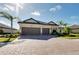 Attractive property featuring a tile roof, two-car garage, paved driveway, and manicured landscaping at 20794 Valprato Ct, Venice, FL 34293
