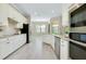 Bright kitchen featuring stainless appliances, granite countertops, and white cabinetry at 20794 Valprato Ct, Venice, FL 34293