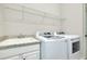 Functional laundry room with a sink, countertop, overhead shelving, and modern appliances at 20794 Valprato Ct, Venice, FL 34293