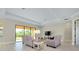 Bright living room with light tile flooring, neutral paint, and sliding glass doors to lanai at 20794 Valprato Ct, Venice, FL 34293