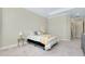 Large bedroom with a tray ceiling, two windows with blinds, bedside tables with lamps, and carpeted floor at 20794 Valprato Ct, Venice, FL 34293