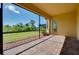 Screened-in patio offers outdoor living space, with brick flooring, overlooking the lush green backyard and landscaping at 20794 Valprato Ct, Venice, FL 34293
