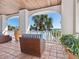 Inviting covered balcony features comfortable seating, elegant columns, and stunning waterfront views at 2110 Casey Key Rd, Nokomis, FL 34275