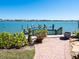 Picturesque waterfront dock featuring a boat lift, lush landscaping, and a stunning view of the water at 2110 Casey Key Rd, Nokomis, FL 34275