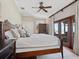 Comfortable bedroom with a ceiling fan, shuttered windows, access to the outside, and en suite bath at 2110 Casey Key Rd, Nokomis, FL 34275