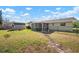 Backyard with lawn, trees, and partially fenced yard and enclosed patio area at 308 Purdue Rd, Venice, FL 34293