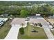 Aerial view of a tan home with an enclosed pool, two garages, long driveway, and waterfront access at 31 Ramblewood St, Port Charlotte, FL 33953