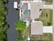 Aerial view of the property shows backyard pool, dock, boat lift and canal front for outdoor enjoyment at 31 Ramblewood St, Port Charlotte, FL 33953