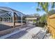 Landscaped backyard featuring a screened in patio, view of the water, and boat dock at 31 Ramblewood St, Port Charlotte, FL 33953