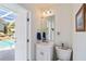 Bathroom with a single sink vanity and view to the screened in pool at 31 Ramblewood St, Port Charlotte, FL 33953
