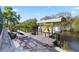 View of the private boat dock with lift on the water, surrounded by lush landscaping and brick paver walkway at 31 Ramblewood St, Port Charlotte, FL 33953