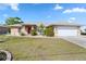 Charming home with well-maintained lawn, lush landscaping, and a large, attached two-car garage at 31 Ramblewood St, Port Charlotte, FL 33953