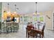 Open kitchen and dining area with wood cabinets, tile floors, breakfast bar, and natural light at 31 Ramblewood St, Port Charlotte, FL 33953