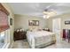 Comfortable main bedroom with ceiling fan, dresser, and view to ensuite bathroom at 31 Ramblewood St, Port Charlotte, FL 33953
