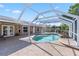 Inviting screened-in pool area with rock features surrounded by a spacious patio at 31 Ramblewood St, Port Charlotte, FL 33953