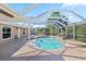 Gorgeous screened-in pool area with rock waterfall, covered patio and seating area provides backyard tranquility at 31 Ramblewood St, Port Charlotte, FL 33953