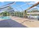 Relax poolside on the patio with a screened enclosure, featuring a boat dock and a rock waterfall at 31 Ramblewood St, Port Charlotte, FL 33953