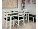 Modern dining area with a wooden table, white chairs, and bench seating at 3224 Mount Hope St, North Port, FL 34287