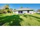 Home exterior featuring a well-maintained lawn, a patio, and mature landscaping at 3447 Nadasky Ave, North Port, FL 34288