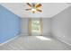 A spacious bedroom features plush carpeting, ceiling fan, and large window at 3447 Nadasky Ave, North Port, FL 34288