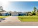 Single-Gathering home with a two car garage, light-blue siding and a bright green lawn at 3447 Nadasky Ave, North Port, FL 34288