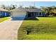 Charming single-story home featuring a manicured lawn and attached two-car garage at 3447 Nadasky Ave, North Port, FL 34288