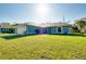 A single-story blue house with a well maintained lawn and palm trees at 3447 Nadasky Ave, North Port, FL 34288
