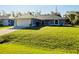 Single-story home showcasing a lush green lawn and an attached two-car garage at 3447 Nadasky Ave, North Port, FL 34288