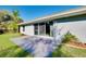 Back patio showcasing sliding glass doors leading inside, complemented by lush lawn and landscape features at 3447 Nadasky Ave, North Port, FL 34288