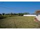 Large, unfenced backyard with lush green grass and the side of the home visible at 358 Pineview Dr, Venice, FL 34293