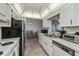 The well-maintained kitchen features white cabinetry, appliances, and a pass-through window at 358 Pineview Dr, Venice, FL 34293