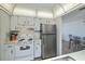 Efficient kitchen features white cabinetry and stainless steel appliances, with an open layout at 358 Pineview Dr, Venice, FL 34293