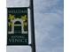 Green welcome sign to Historic Venice, established in 1927, featuring palm trees and classic architecture against a blue sky at 358 Pineview Dr, Venice, FL 34293