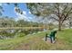 Picturesque pond view with a bench under a shady tree at 3730 Cadbury Cir # 429, Venice, FL 34293