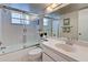 Clean bathroom with a tiled shower and tub, a marble countertop, and a decorative mirror at 418 Cerromar Ct # 261, Venice, FL 34293