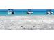 Beautiful white sand beach with clear blue water, highlighting several boats anchored just offshore at 418 Cerromar Ct # 261, Venice, FL 34293