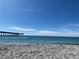 Beach view with clear blue sky and ocean with pier in the distance, perfect for outdoor activities at 418 Cerromar Ct # 261, Venice, FL 34293