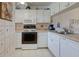 Bright kitchen featuring white cabinets, appliances, and tiled backsplash at 418 Cerromar Ct # 261, Venice, FL 34293