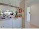 Bright kitchen featuring white dishwasher and stainless steel sink overlooking living room at 418 Cerromar Ct # 261, Venice, FL 34293