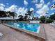 Community pool surrounded by lounge chairs, palm trees, and lush landscaping at 418 Cerromar Ct # 261, Venice, FL 34293