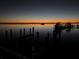 Waterfront at dusk with dock and boats, highlighting a peaceful evening with the colors of twilight at 418 Cerromar Ct # 261, Venice, FL 34293