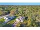 An aerial perspective showing the front of the house with a brick driveway and lush trees in the background at 4324 Knowles Ln, North Port, FL 34288