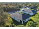 An aerial view showing the home's backyard, the house, and its surroundings with lush green trees at 4324 Knowles Ln, North Port, FL 34288