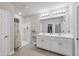 Bright bathroom featuring a double sink vanity, walk-in shower, and a large mirror reflecting the closet at 4324 Knowles Ln, North Port, FL 34288