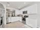 Bright kitchen with stainless appliances, white cabinets, and view into adjacent living room at 4324 Knowles Ln, North Port, FL 34288